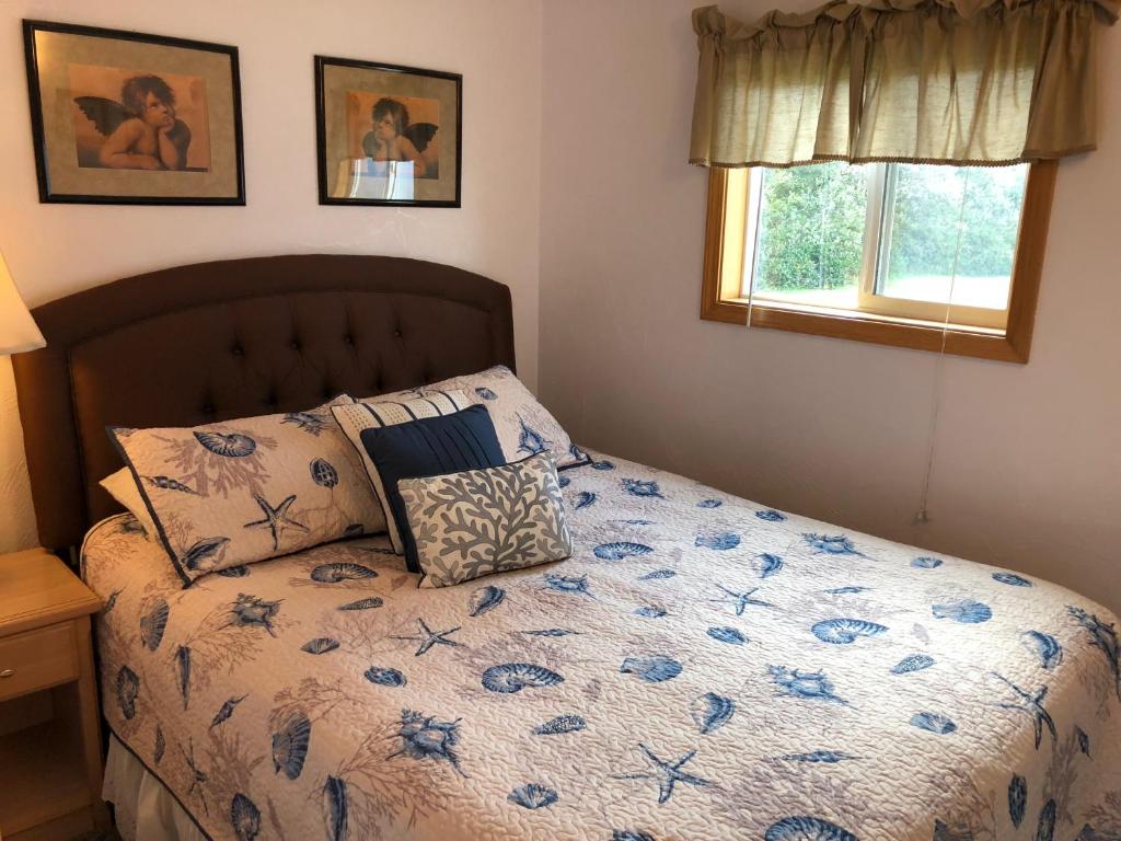 a bedroom with a bed with a blue floral comforter at Westerly Motel in Ocean Shores