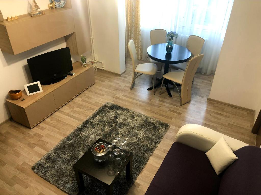 a living room with a couch and a table with a tv at Apartament Antonia Sat Vacanta in Constanţa