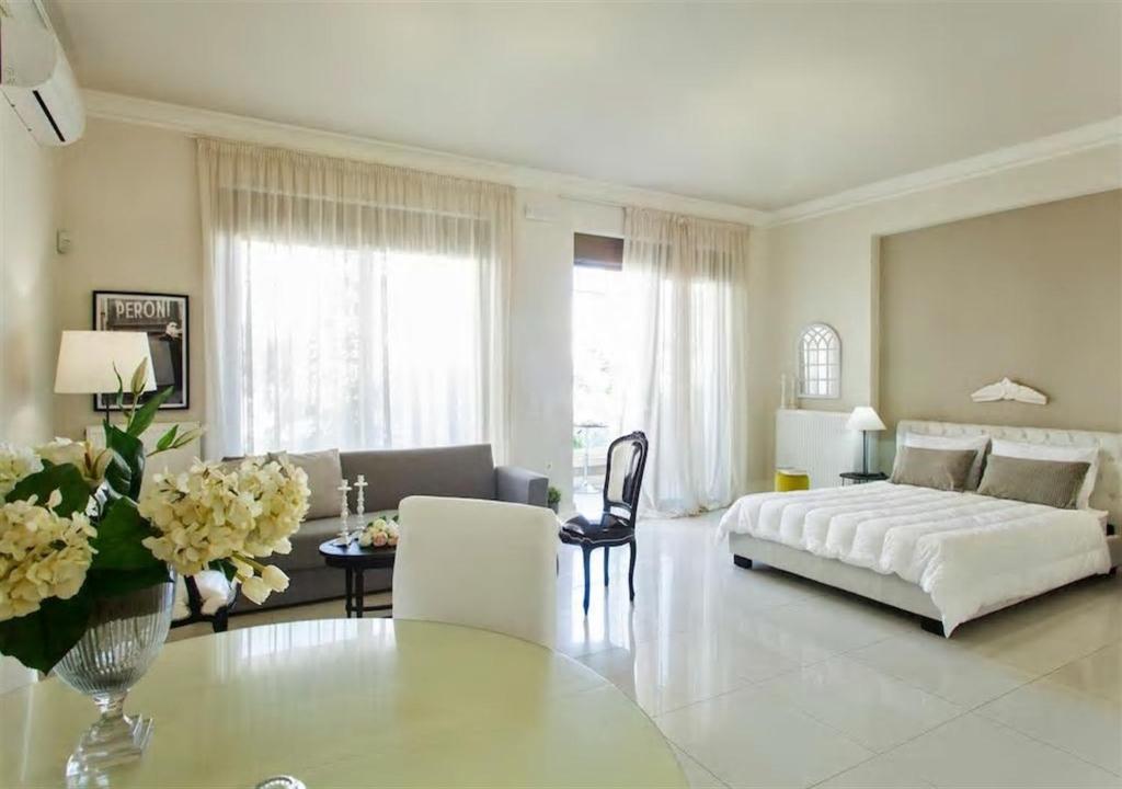 ein großes weißes Wohnzimmer mit einem Bett und einem Tisch in der Unterkunft Maritina Apartment in Iraklio