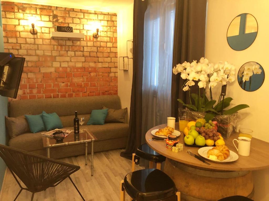 un soggiorno con tavolo, frutta e divano di Dubrovnik Summer Industry Apartment a Dubrovnik