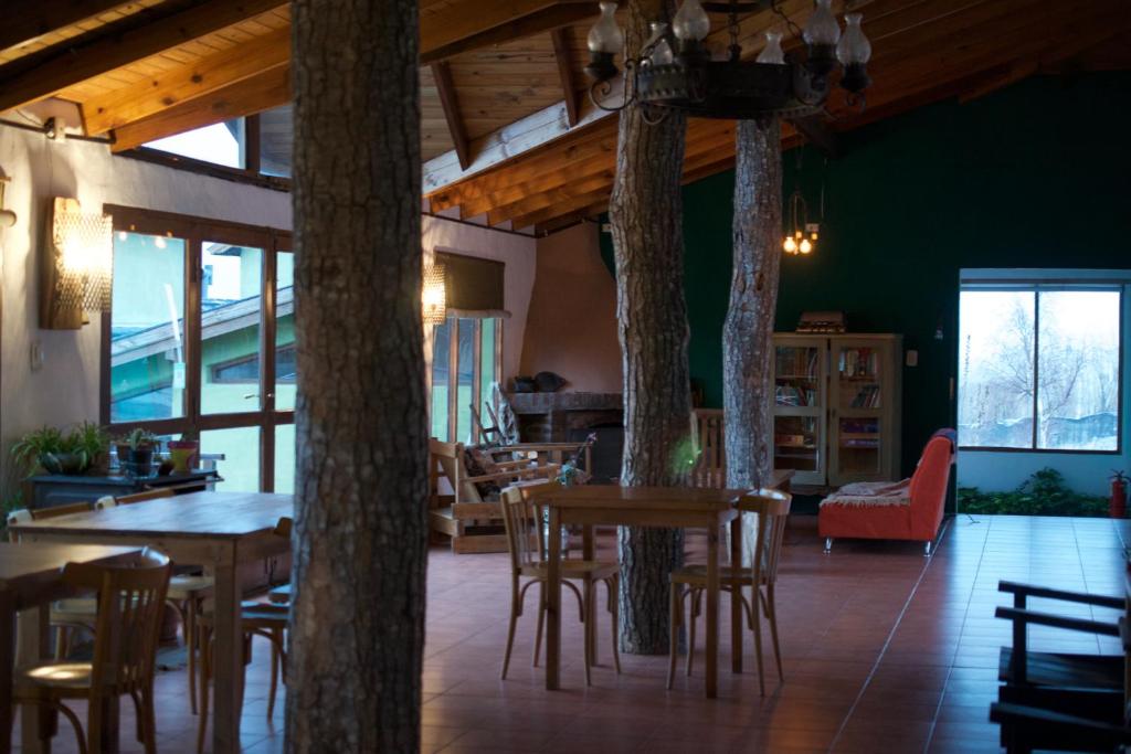 ein Wohnzimmer mit einem Tisch, Stühlen und Bäumen in der Unterkunft Bla Lodge in El Calafate