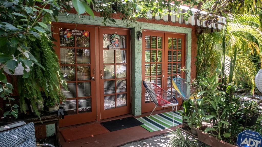 a porch with a red door and a chair at The Wild Rose in Miami