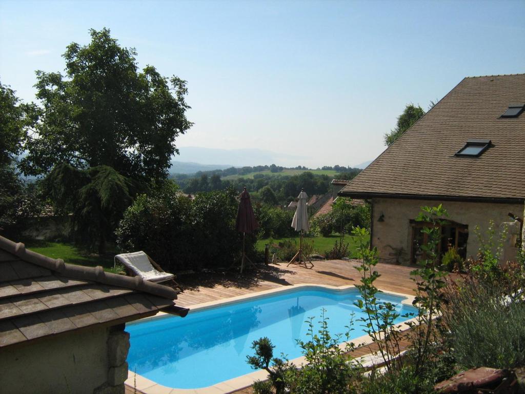 a swimming pool in a yard next to a house at Villanath in Bellegarde-sur-Valserine