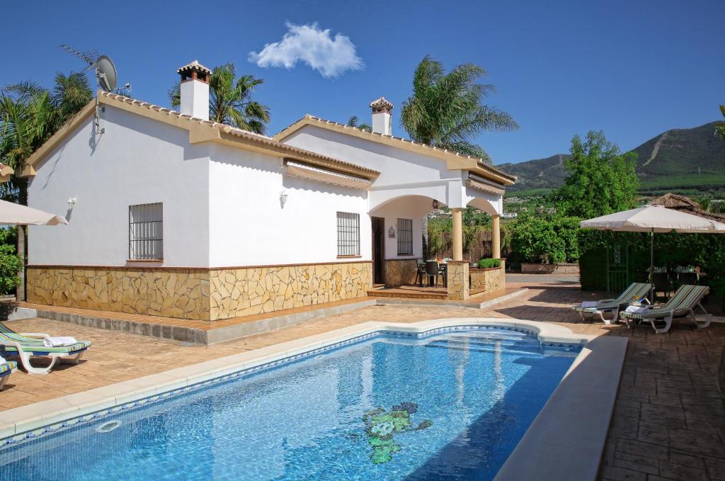 a villa with a swimming pool in front of a house at Casa Rural Típica Andaluza, WiFi,Piscina, Barbacoa, Aire Acondicionado, 5min Centros in Alhaurín el Grande