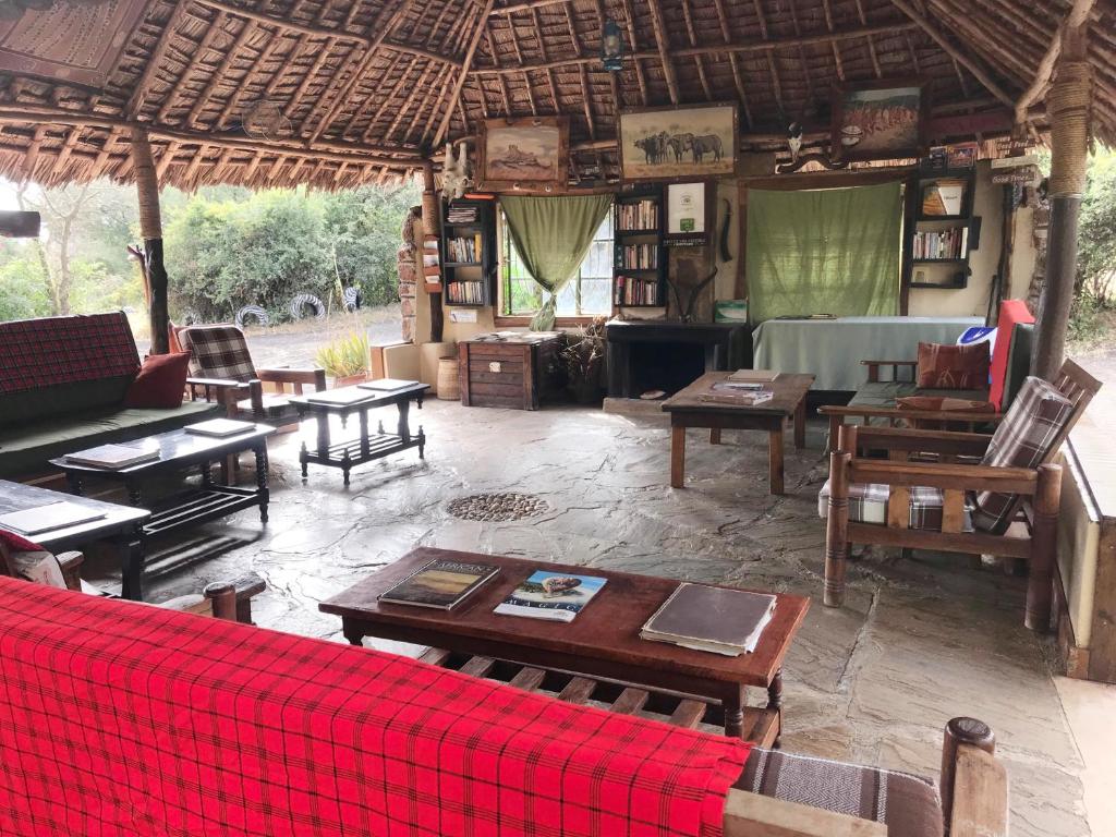 a living room with tables and chairs in a house at Maasai Simba Camp in Amboseli
