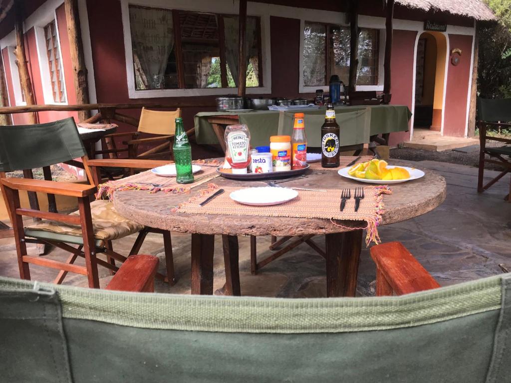 an outdoor table with drinks and plates of food on it at Maasai Simba Camp in Amboseli