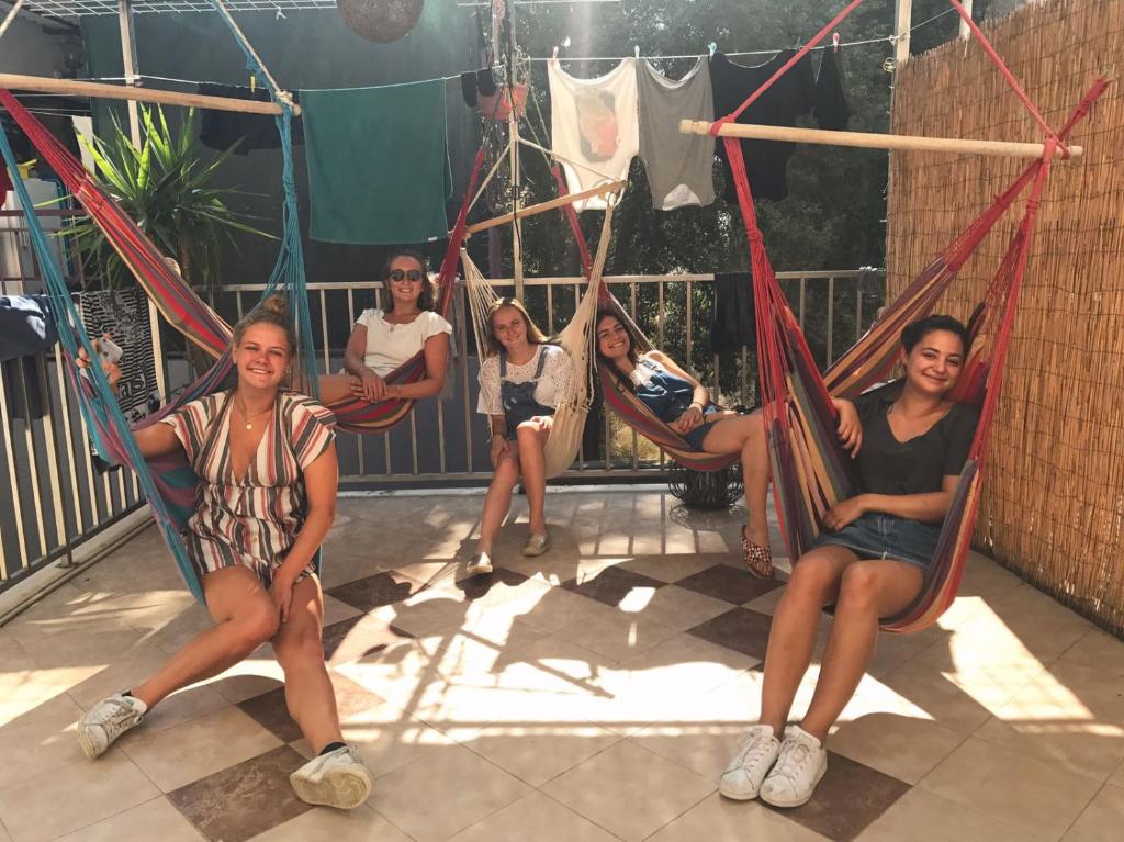 a group of people sitting in hammocks on a porch at Hostel Wonderful World in Split
