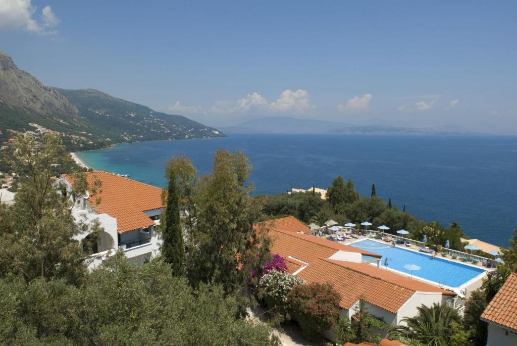 a view of a resort with a pool and the ocean at Nautilus Barbati in Barbati