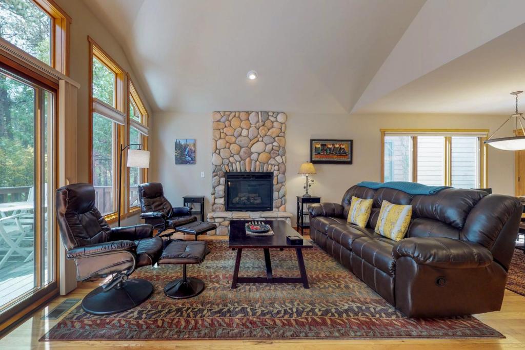 a living room with a leather couch and a fireplace at River Retreat - Permit #3517 in Estes Park