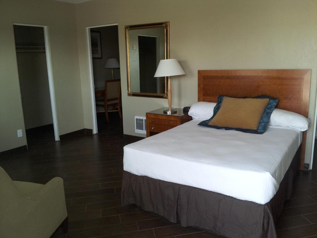 a hotel room with a bed and a mirror at Oasis Boutique Motel in Boulder City