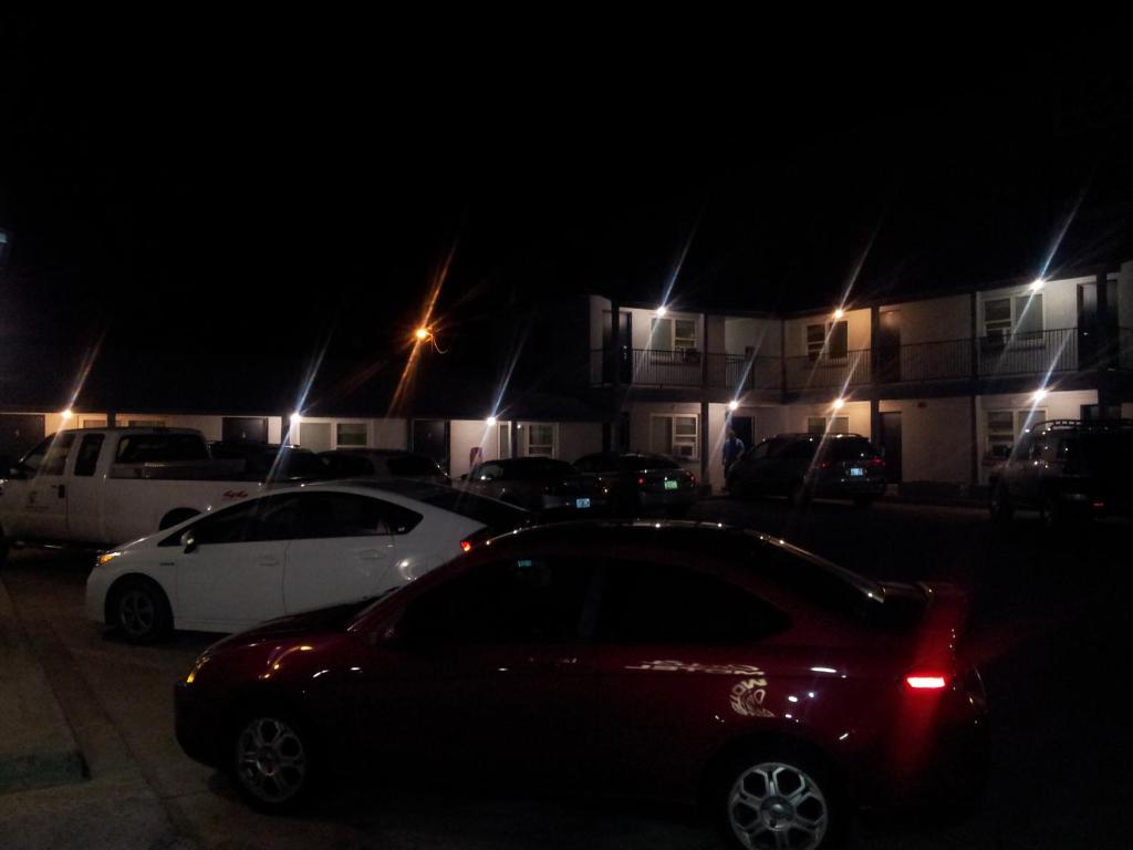 a red car parked in a parking lot at night at Oasis Boutique Motel in Boulder City