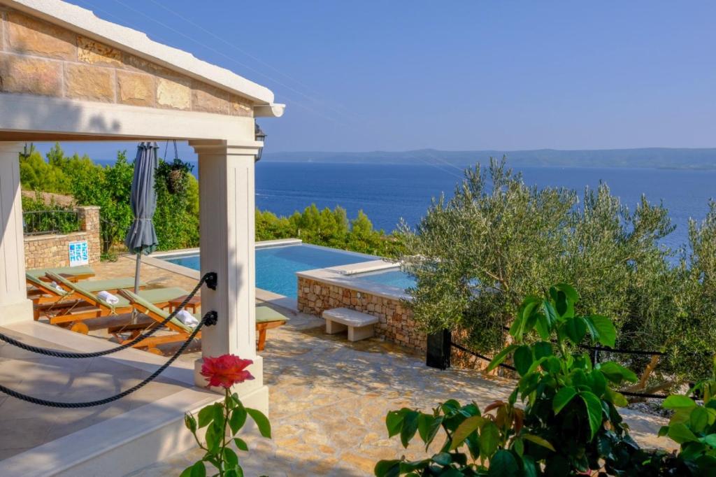 a villa with a pool and a view of the ocean at Villa Lucija Bol in Bol