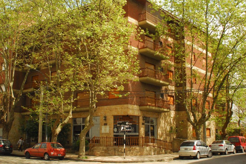 un edificio de ladrillo rojo con coches aparcados delante de él en Hotel 30 de Octubre en Mar del Plata