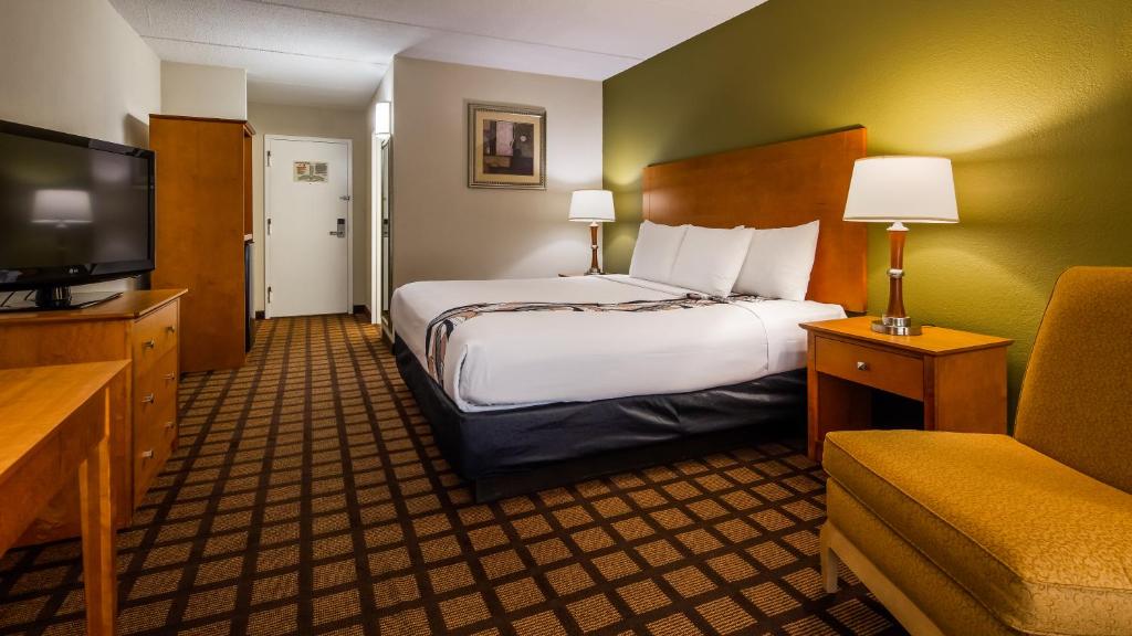 a hotel room with a bed and a television at Best Western Plus Chicago Hillside in Hillside