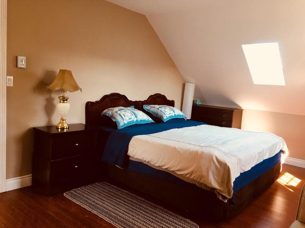a bedroom with a bed with blue and white sheets at Seaview White House in Stratford