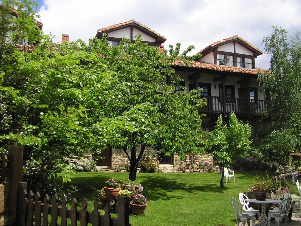 a house with a fence in front of a yard at Apartamento Fuente De Somave in Cahecho