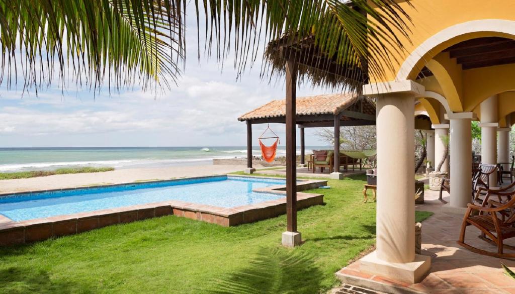 Casa Cantamar في Iguana: منزل به مسبح بجوار الشاطئ