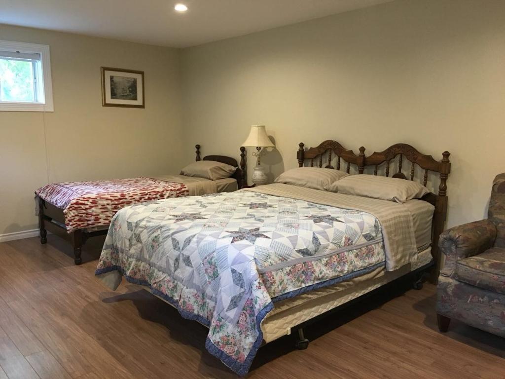 a bedroom with two beds and a chair at Seaview White House in Stratford