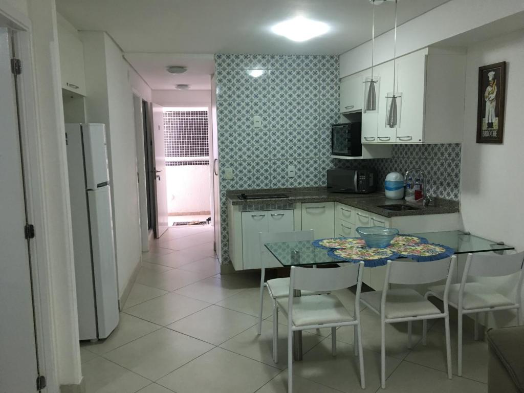 cocina con mesa y sillas y cocina con nevera en Luxo na Beira Mar, en Fortaleza