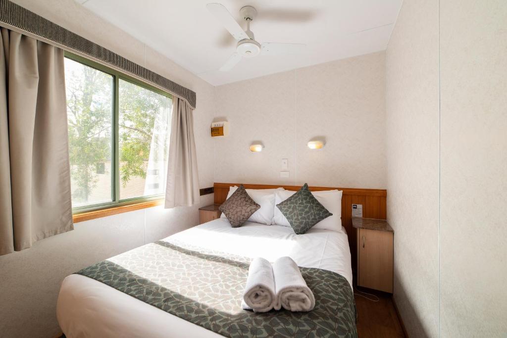 a bedroom with a white bed and white walls at Breeze Holiday Parks - Halls Gap in Halls Gap