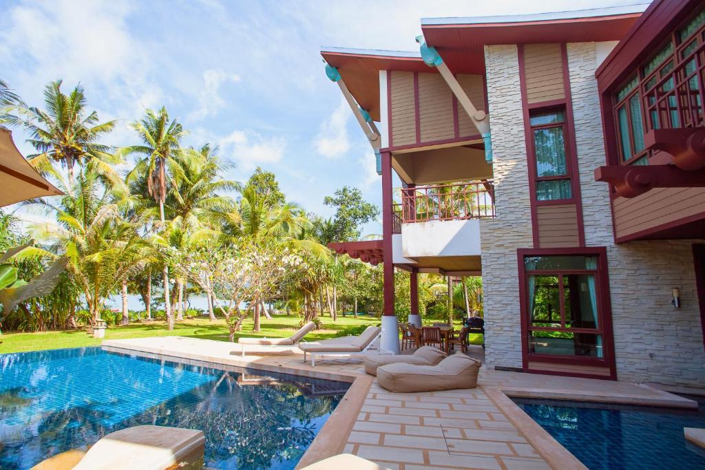 a house with a swimming pool next to a building at Amatapura Beachfront Villa 1, SHA Certified in Ao Nam Mao