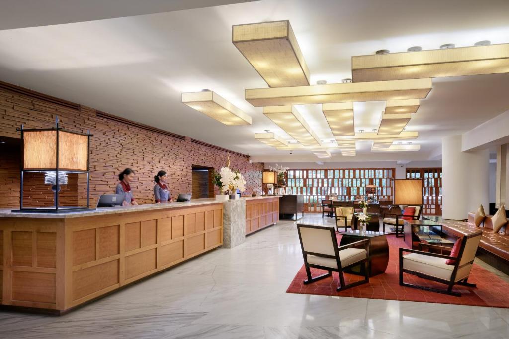 A spacious reception lobby with a library-style lounge and two staffed counters.
