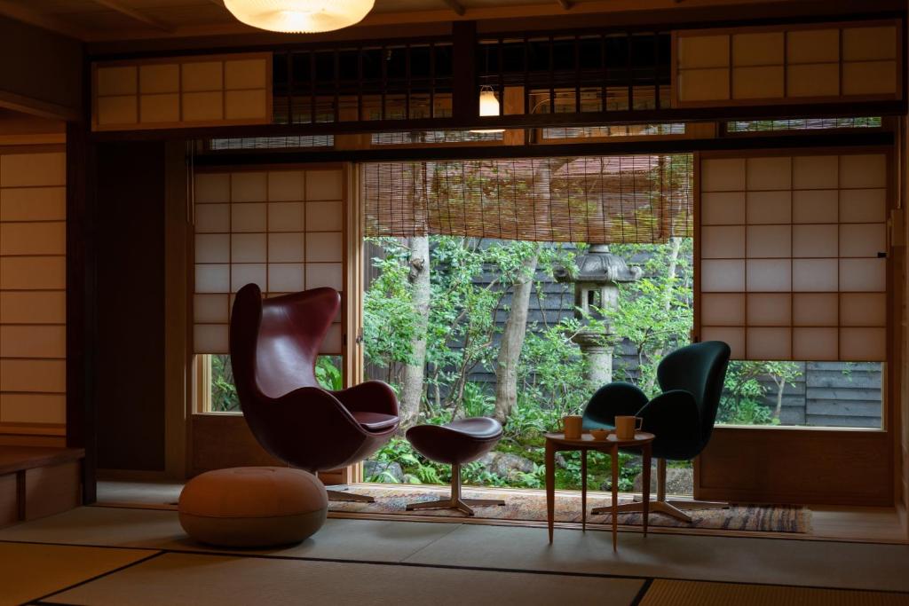 a room with chairs in front of a window at Hotel Koo Otsuhyakucho in Otsu
