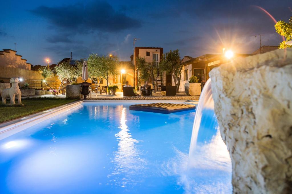 een zwembad met een waterval in een achtertuin 's nachts bij La Locanda di Zì Nicola in Matera