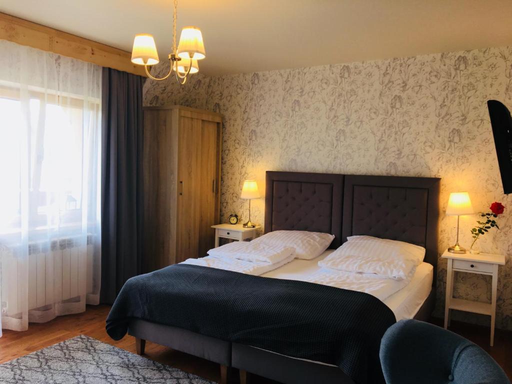 a bedroom with a large bed with white pillows at Apartamenty w Jurgowie Świstokówka in Jurgów