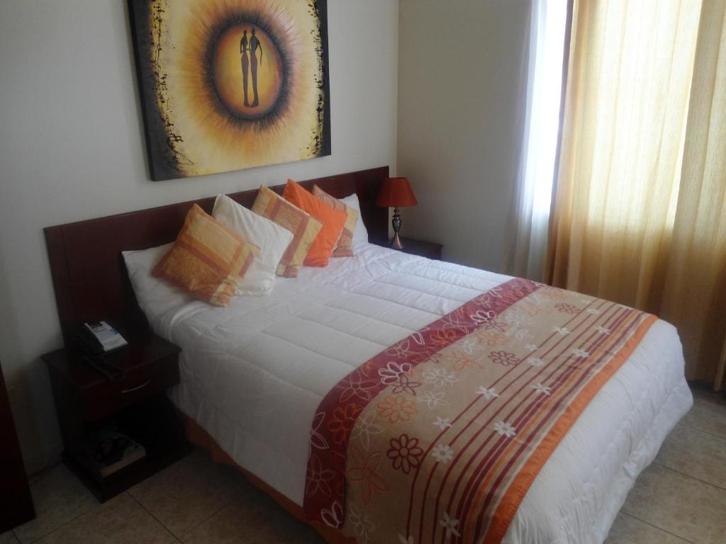 a bedroom with a large bed with pillows at Hotel Air Suites in Guayaquil