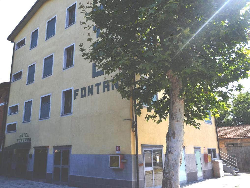 ein Gebäude mit einem Baum davor in der Unterkunft Hotel Fontana in Rubiera