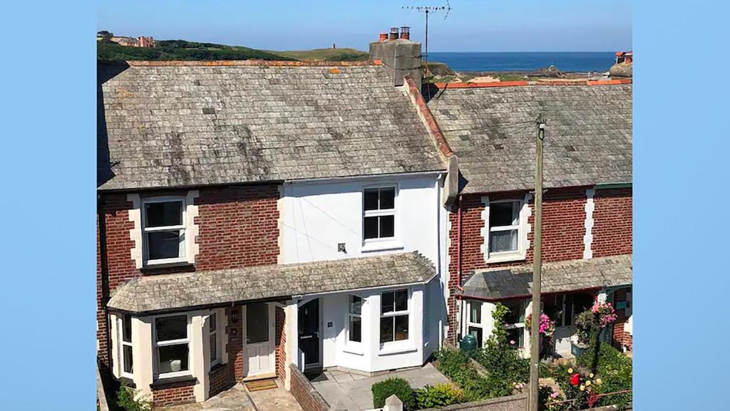 an aerial view of two houses with the ocean in the background at Driftwood Cottage in Bude