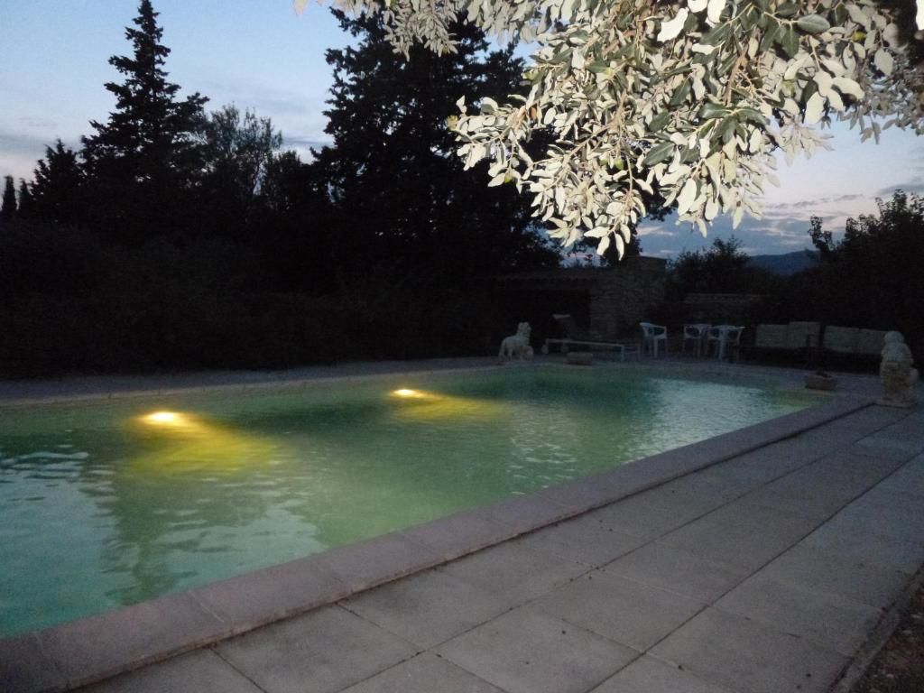 una piscina por la noche con luces en el agua en Les Gites du Mont Ventoux, en Bédoin