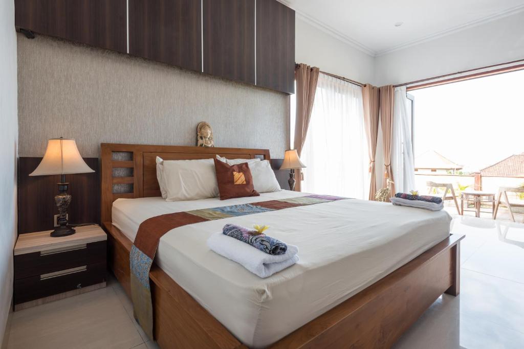 a bedroom with a large bed with towels on it at Villa Melasti Wardana in Uluwatu