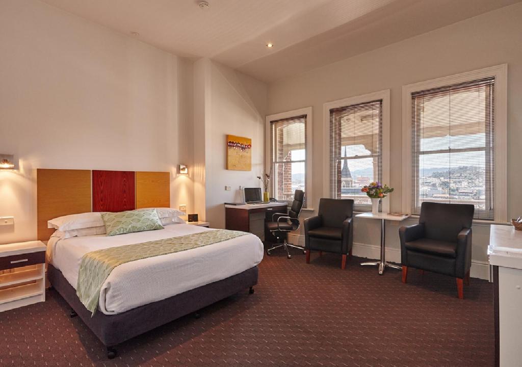 een hotelkamer met een bed, een bureau en stoelen bij Auldington Hotel in Launceston