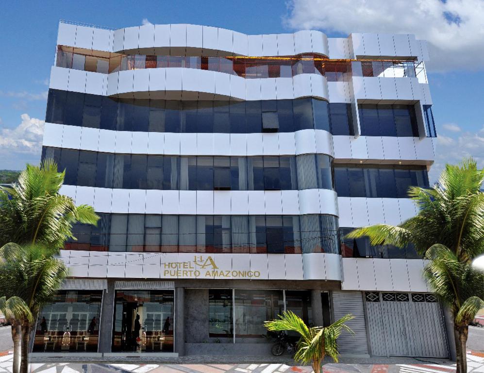 un grande edificio con palme di fronte di Hotel Puerto Amazonico a Puerto Maldonado