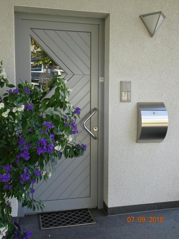 a door to a house with a mailbox and purple flowers at Traumferienwohnung zwischen Köln und Düsseldorf in Leichlingen
