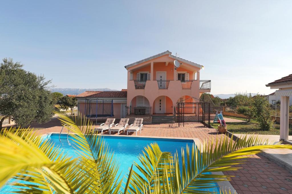 a house with a swimming pool in front of a house at Villa Paludo in Novigrad Dalmatia