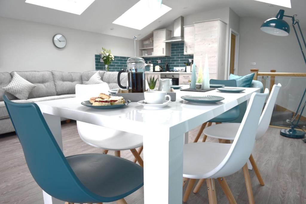 a kitchen and dining room with a white table and chairs at Lighthouse View 2 in Westward Ho