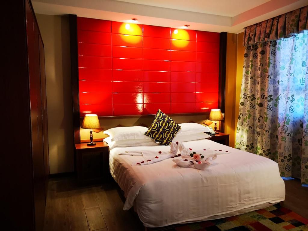 a bedroom with two beds and a red headboard at Great Wall Hotel in Dar es Salaam