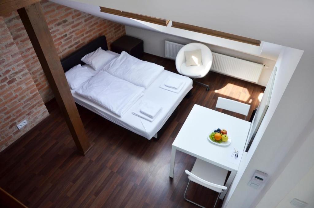 プラハにあるThe Republic Apartmentsのベッドとテーブル付きの小さな部屋