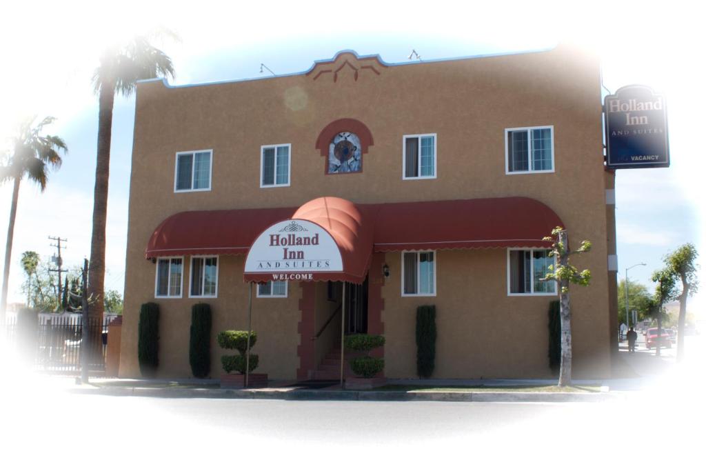 a building with a sign in front of it at Holland Inn and Suites in Taft