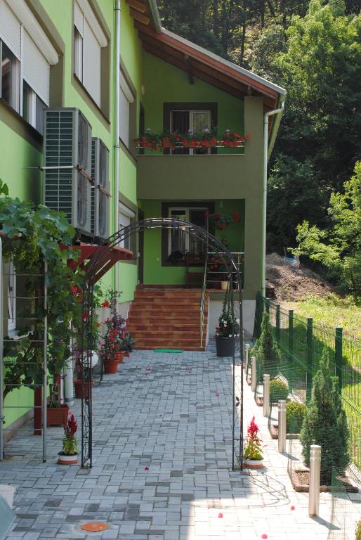 une maison verte avec un escalier et un balcon dans l'établissement Casa Flori de Nuc, à Moneasa