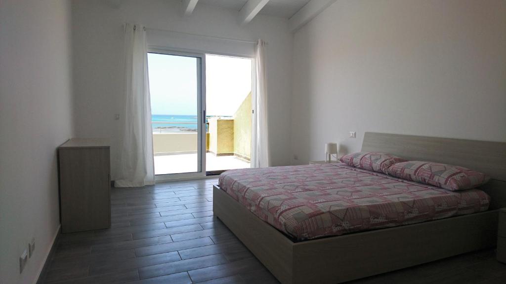 a bedroom with a bed and a view of the ocean at SGC Boa Vista Apartments in Sal Rei
