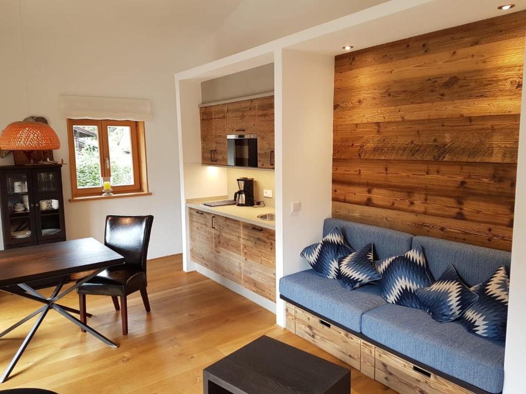 a living room with a blue couch and a wooden wall at Ferienwohnung Springer in Schliersee