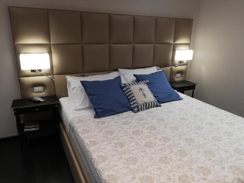 um quarto com uma cama grande e almofadas azuis em Les Chambres de la Place em Sanremo