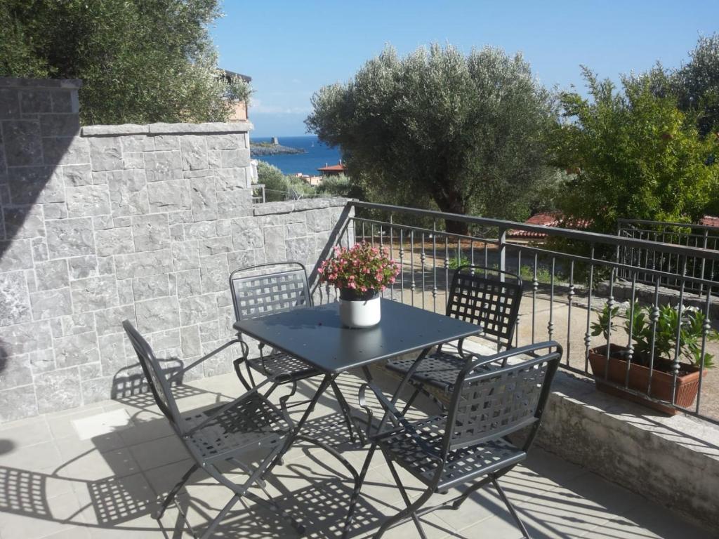 una mesa y sillas en un patio con una pared de piedra en Appartamenti La Chiandata, en Marina di Camerota