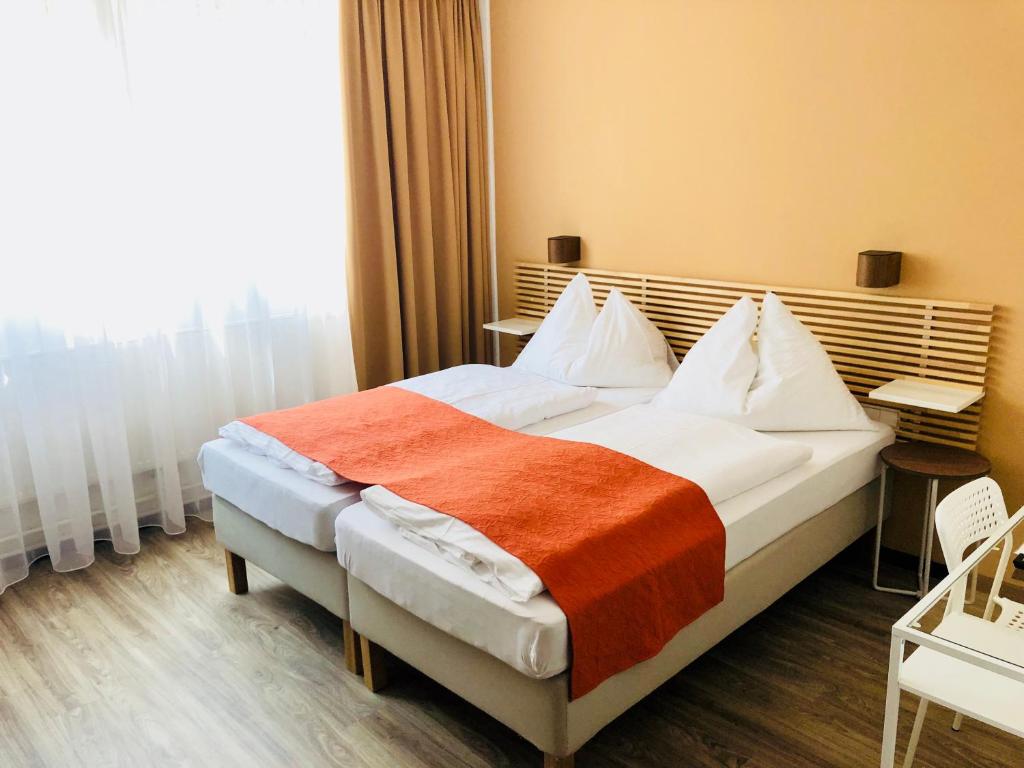 ウィーンにあるAparthotel Biancaのベッドルーム1室(大型ベッド1台、オレンジの毛布付)