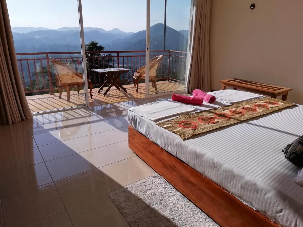 a bedroom with a bed and a balcony with a view at High View Homestay in Kandy