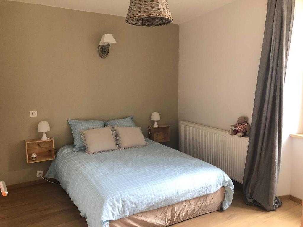 um quarto com uma cama com lençóis e almofadas azuis em La cabine de Loire em Saint-Satur